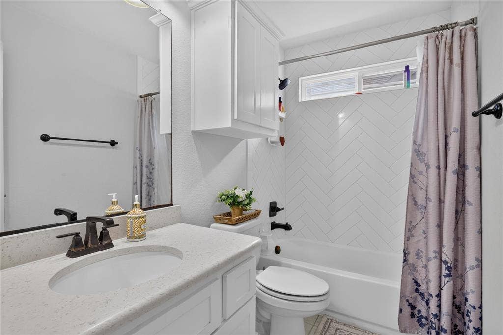 White vanity with an integrated sink and bronze-finish faucet