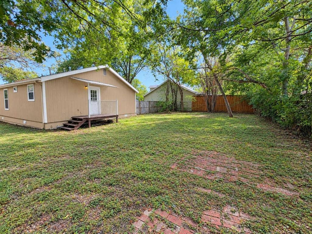 1203 N College Street, McKinney, TX 75069 Expansive grassy yard with mature trees and a wood privacy fence