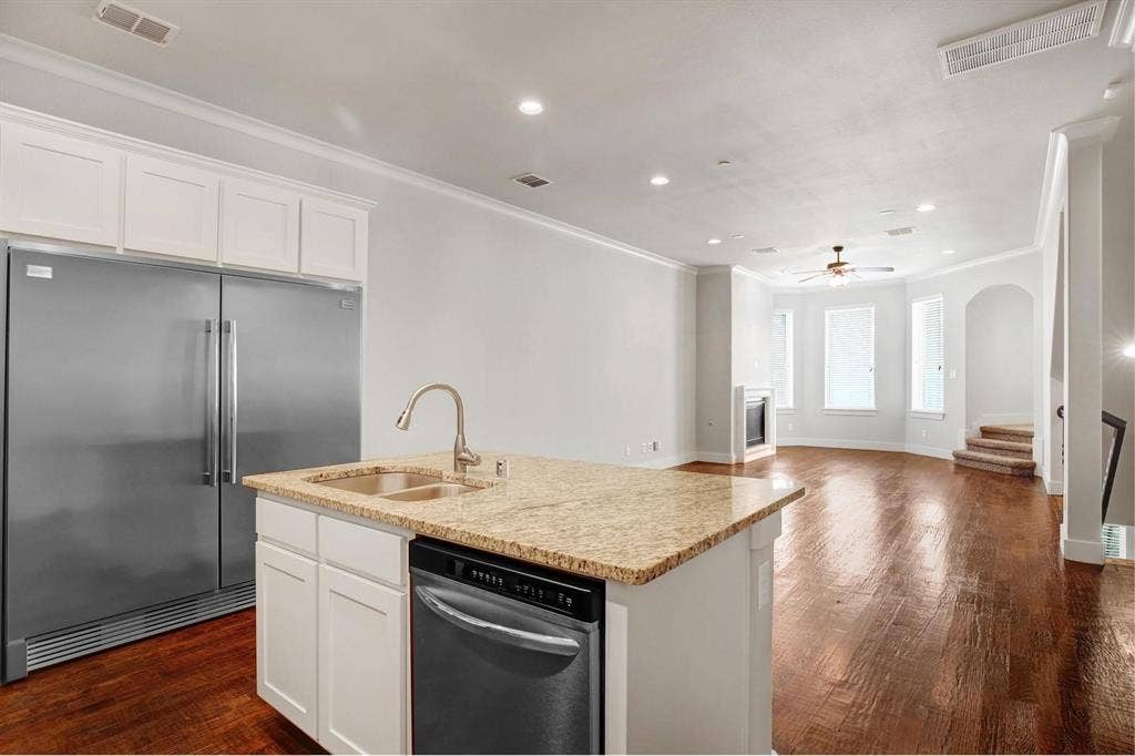 Kitchen island with granite countertop, double basin sink, and integrated dishwasher