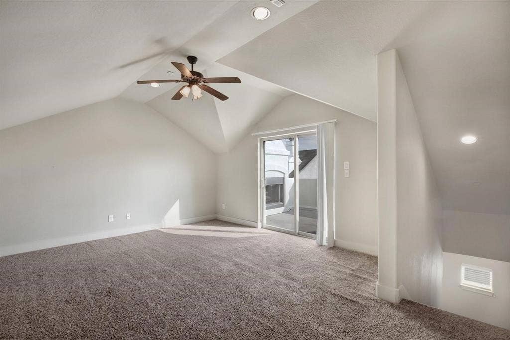 Sloped ceilings with recessed lighting, ceiling fan with wood-finish blades, sliding glass door, and carpeted flooring
