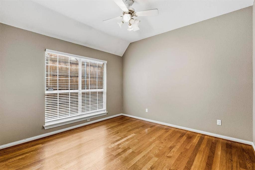 3916 Montrose Drive, Plano, TX 75025 Vaulted ceiling with a ceiling fan, light neutral wall paint, wood-finish flooring, and a large window with white blinds
