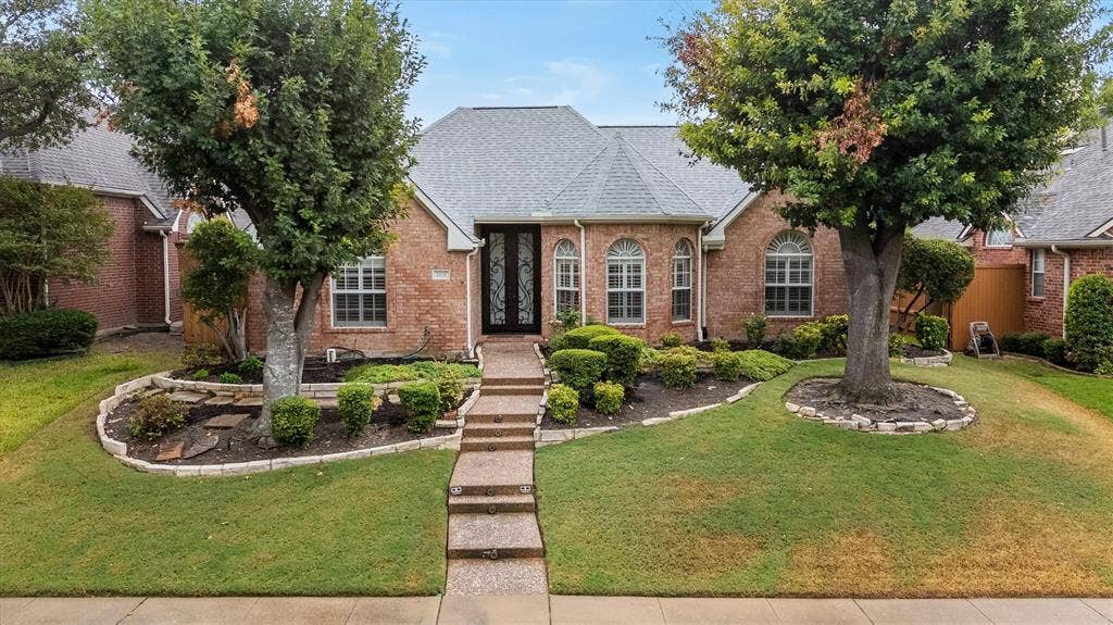 3916 Montrose Drive, Plano, TX 75025 Brick exterior with arched windows, a double entry door, and a gray shingle roof