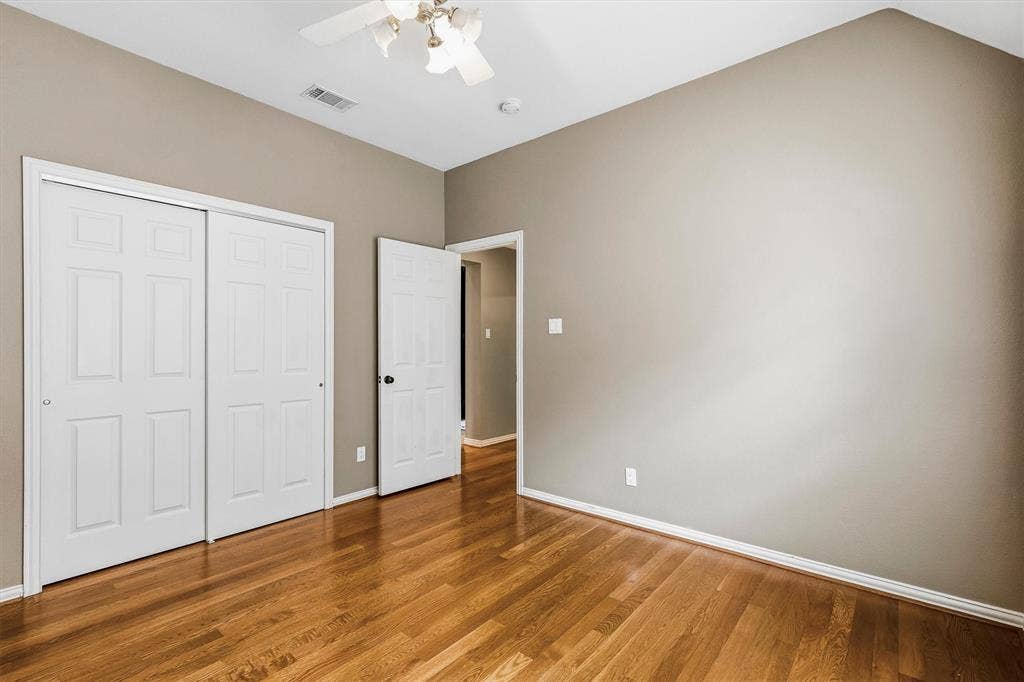 3916 Montrose Drive, Plano, TX 75025 Wood-finish flooring, vaulted ceiling, ceiling fan with integrated lighting, two-panel closet doors, and neutral wall paint