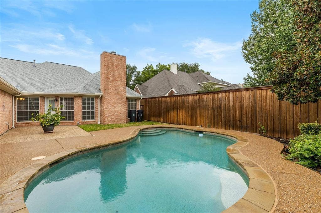 3916 Montrose Drive, Plano, TX 75025 Backyard oasis featuring a free-form swimming pool, stone coping, and an expansive concrete patio