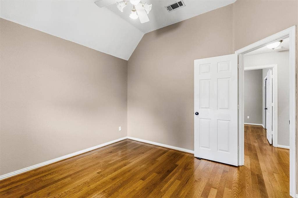 3916 Montrose Drive, Plano, TX 75025 Vaulted ceiling with a ceiling fan, wood-finish flooring, and a paneled door with black hardware