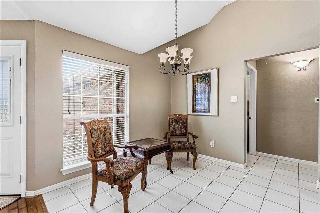 3916 Montrose Drive, Plano, TX 75025 Vaulted ceiling, white tile flooring, large window with blinds, wall sconce lighting, and a chandelier