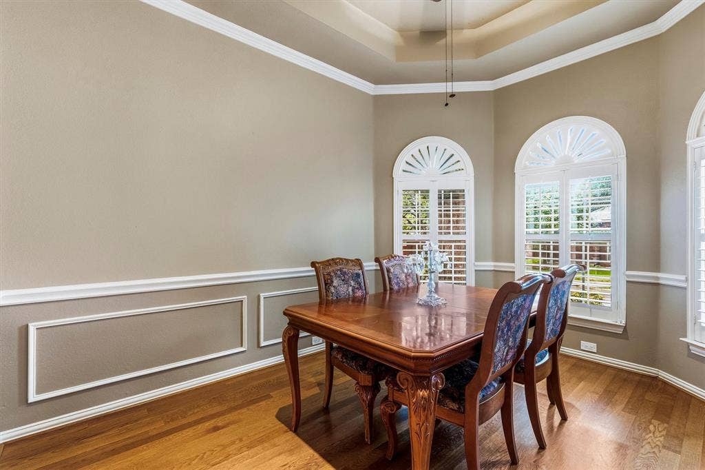 3916 Montrose Drive, Plano, TX 75025 Tray ceiling, arched windows with plantation shutters, crown molding, chair rail with picture frame molding, and wood-finish flooring
