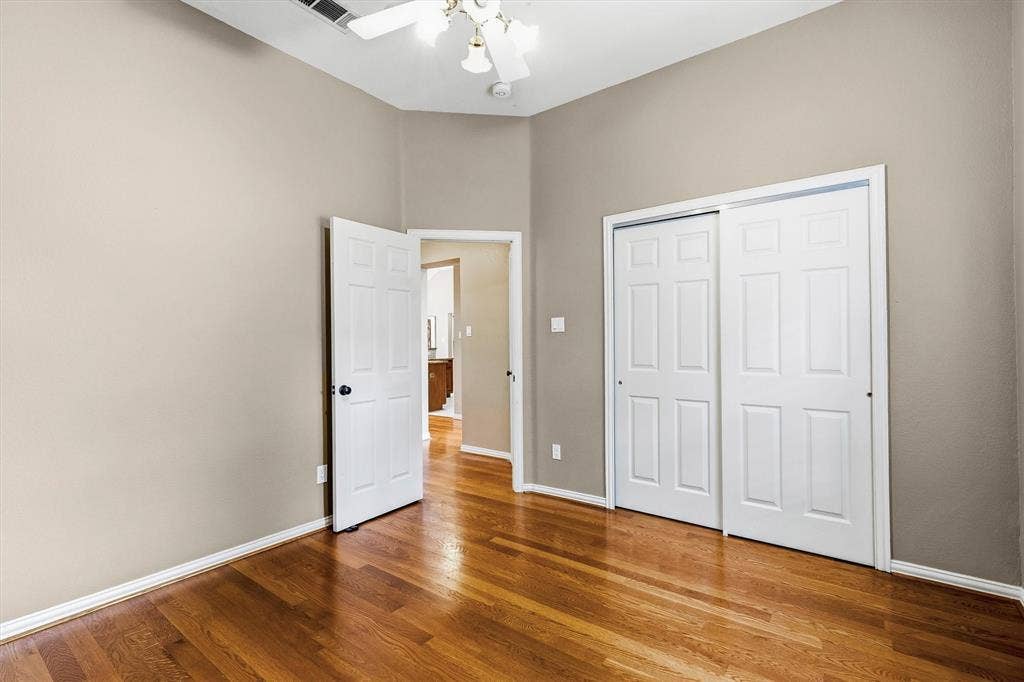 3916 Montrose Drive, Plano, TX 75025 Vaulted ceiling, ceiling fan with light fixture, wood-finish flooring, two-panel sliding closet doors, and a paneled interior door