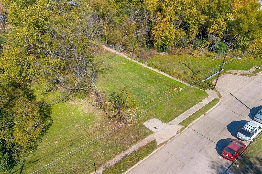 2433 52nd Street, Dallas, TX 75216 Expansive lot featuring mature trees, a manicured lawn, and paved road frontage