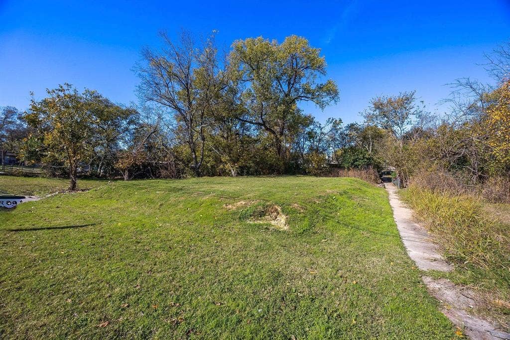 2433 52nd Street, Dallas, TX 75216 Expansive grassy area with mature trees and a concrete pathway