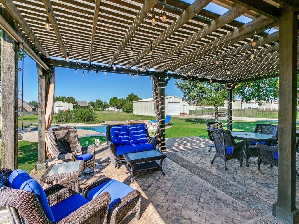 508 Singing Quail Trail, Haslet, TX 76052 Expansive outdoor living area featuring a wooden pergola, string lighting, patterned concrete patio, and a swimming pool