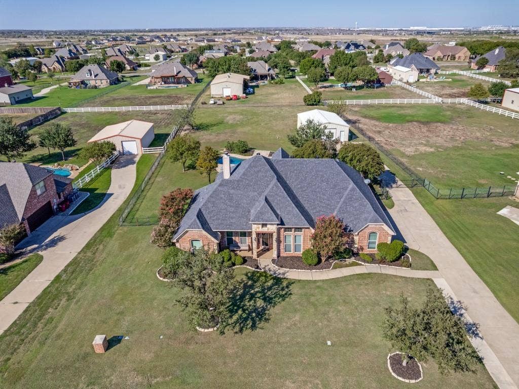 508 Singing Quail Trail, Haslet, TX 76052 Brick residence with a dark shingle roof, extensive concrete driveway, and mature landscaping