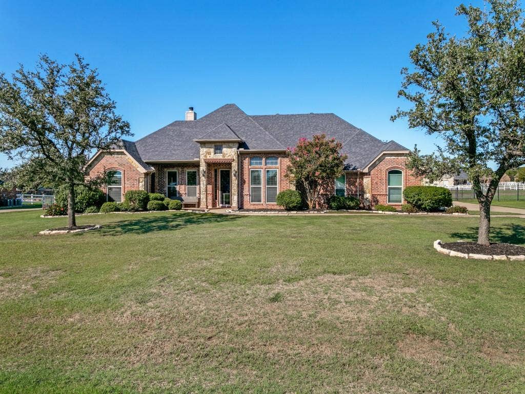 508 Singing Quail Trail, Haslet, TX 76052 Brick exterior with stone accents, a dark shingle roof, and mature landscaping
