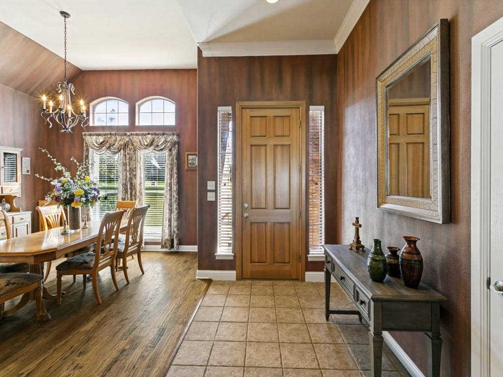 508 Singing Quail Trail, Haslet, TX 76052 Wood-finish flooring, tiled entry, arched transom windows, and a chandelier with decorative scrollwork