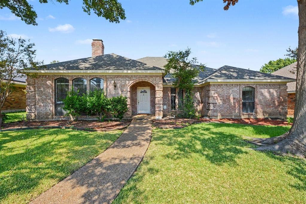 3313 Anchor Drive, Plano, TX 75023 Brick exterior with arched entry, arched windows, a single chimney, and a paved walkway