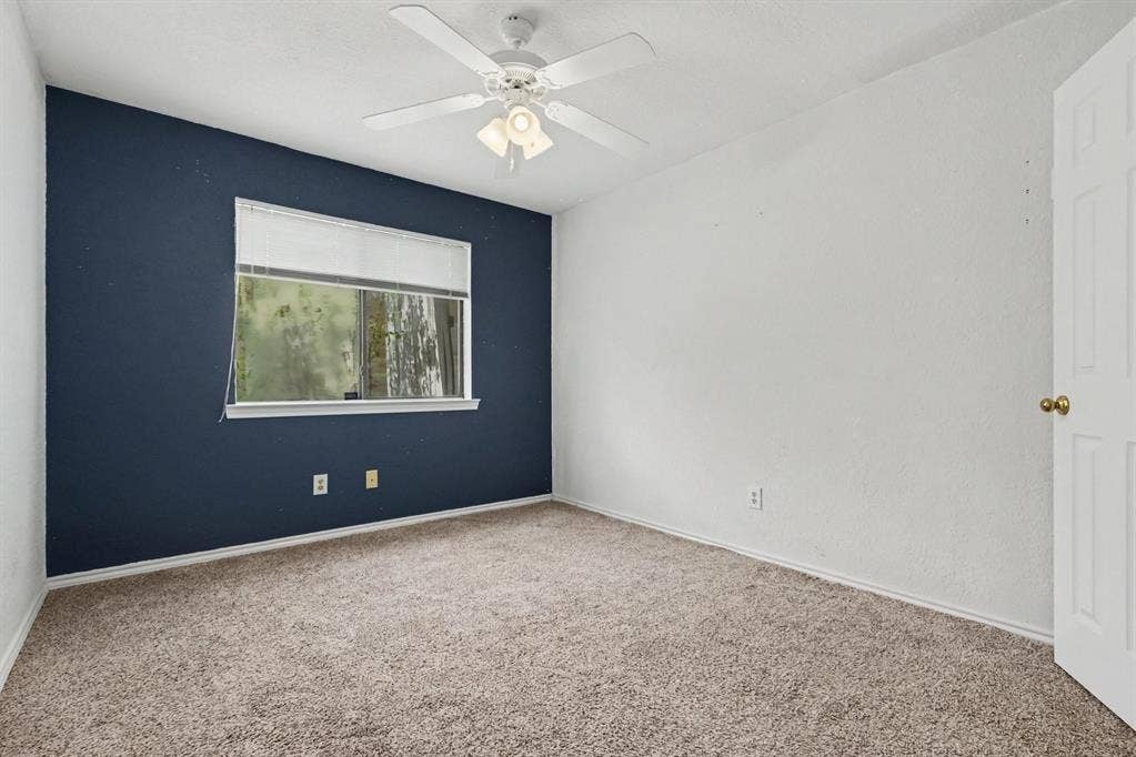 3313 Anchor Drive, Plano, TX 75023 Wall-to-wall carpeting, window with blinds, ceiling fan with integrated lighting, and a paneled door with brass-finish hardware