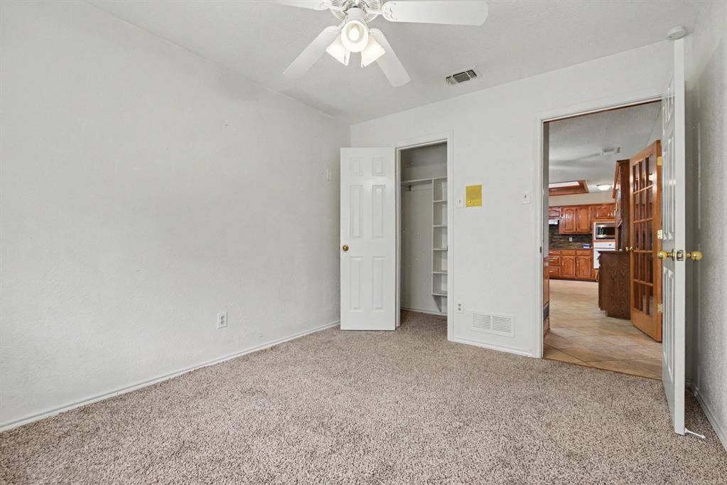 3313 Anchor Drive, Plano, TX 75023 Neutral-toned carpeting, white walls, and a ceiling fan with integrated lighting