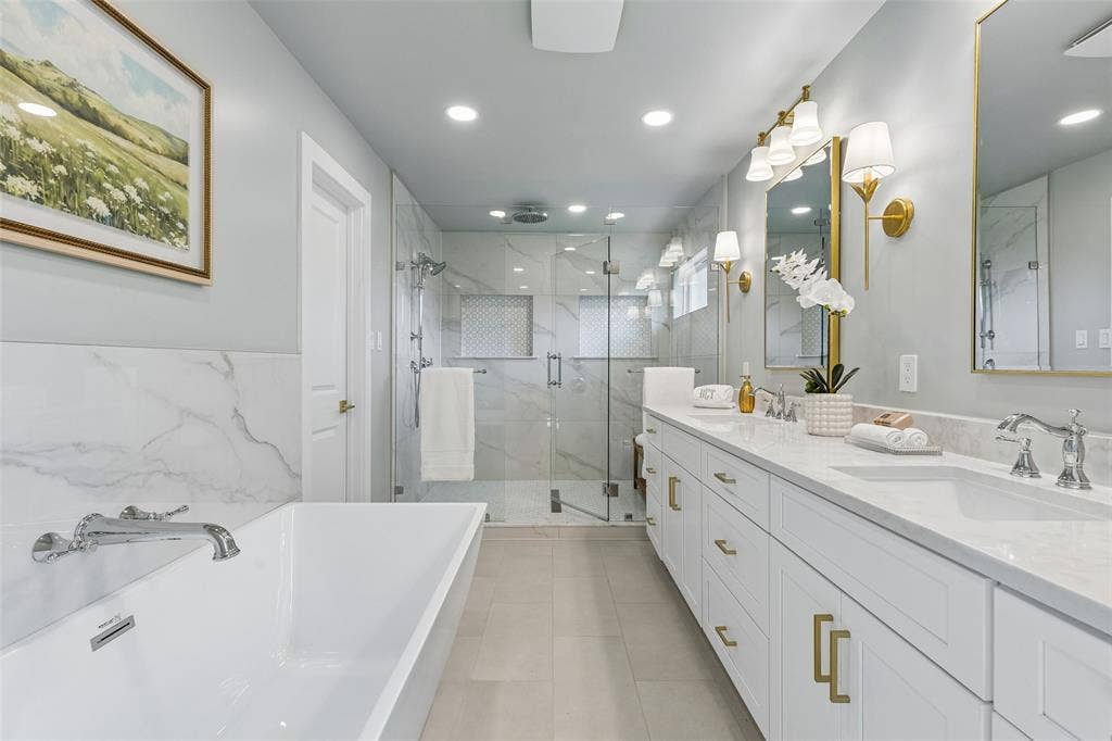 11864 Cold Harbor Lane, Dallas, TX 75244 Updated primary bath with dual sinks, a freestanding tub and an oversized frameless glass shower with dual showerheads.