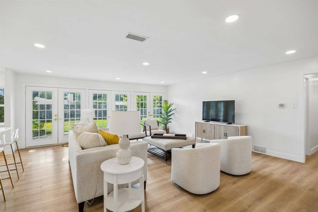 11864 Cold Harbor Lane, Dallas, TX 75244 Spacious living area with LVT floors, recessed lighting and multiple French doors opening to the backyard.