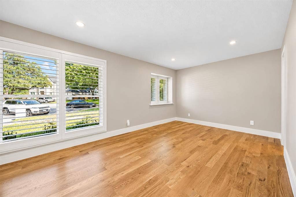 Oversized secondary bedroom with built in cabinetry, custom closet, and oak hardwood floors