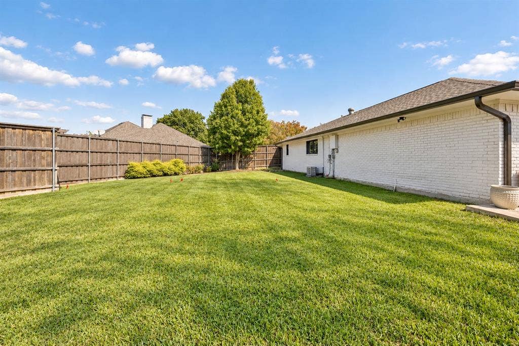 Spacious backyard featuring a manicured lawn on over one-third acre lot connected all the way around the property by a gated fence. Enjoy the pool or yard all in one.