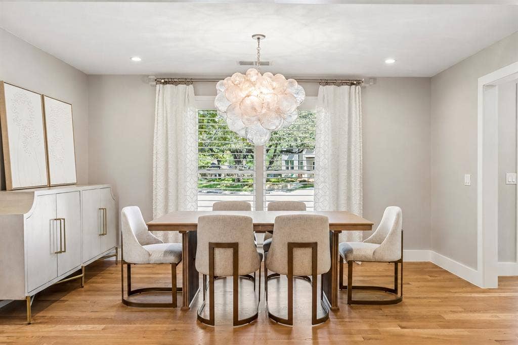Rich wall tones, spherical glass chandelier, and beautiful view of cul de sac
