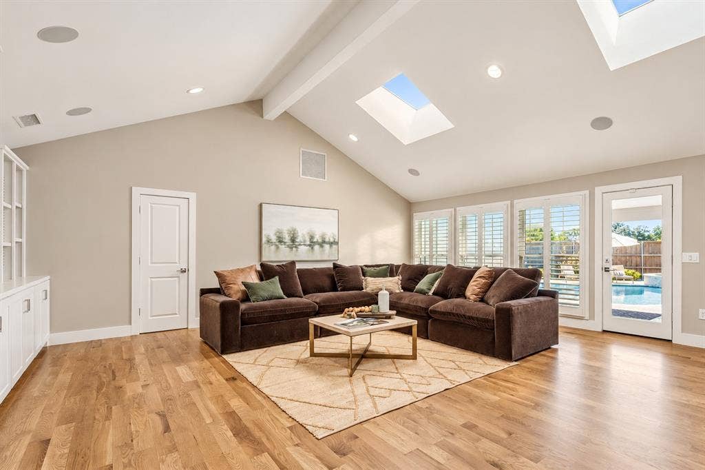 Vaulted ceiling with multiple skylights, wood-finish flooring, built in custom cabinetry, views of the Blue Haven pool and spa
