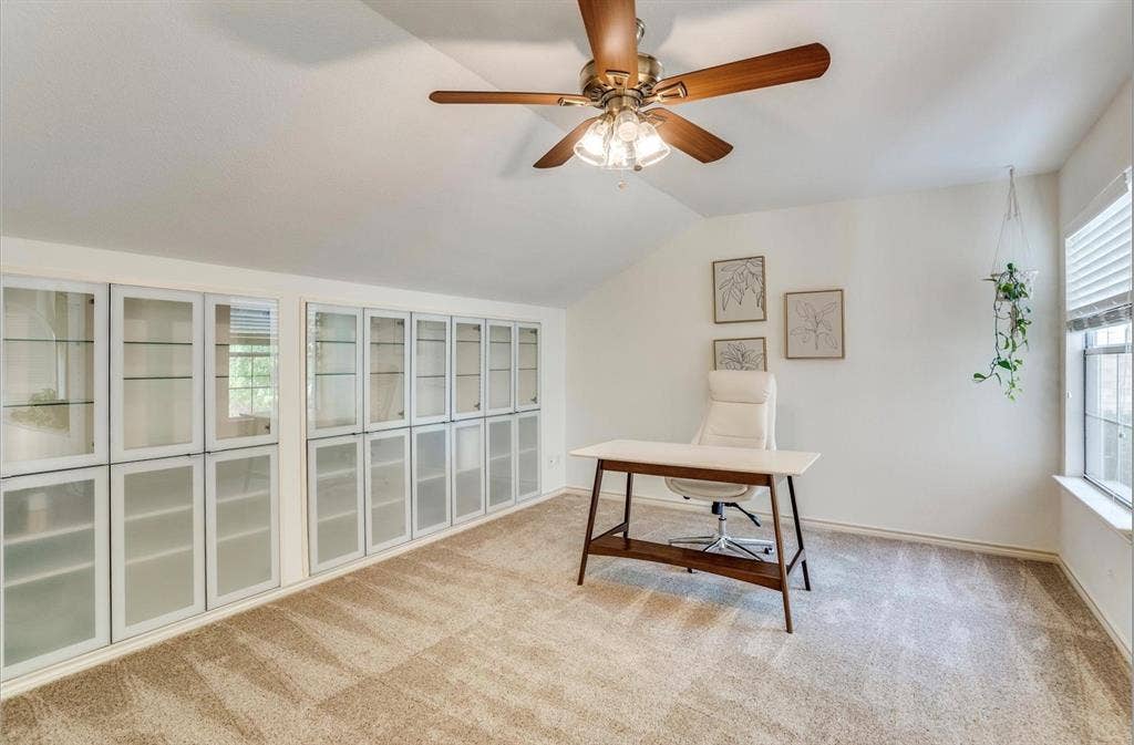 1944 Vantage Drive, Plano, TX 75075 Vaulted ceiling with a ceiling fan, plush carpet, extensive built-in cabinetry with glass doors, and a window with blinds
