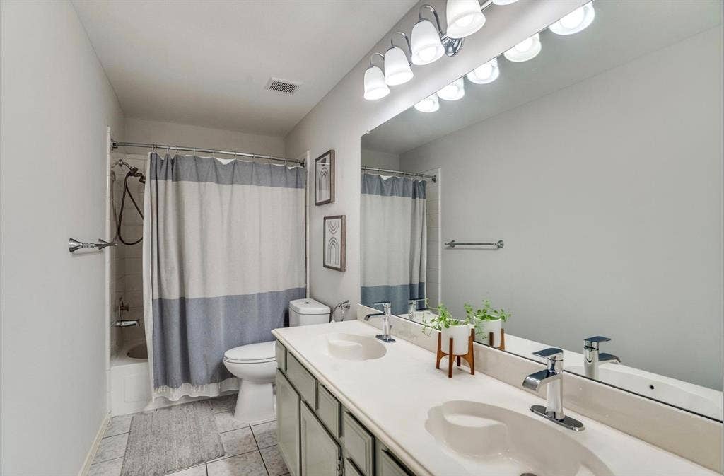 1944 Vantage Drive, Plano, TX 75075 Dual vanity with integrated sinks, chrome fixtures, and an expansive mirror