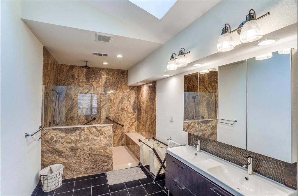 1944 Vantage Drive, Plano, TX 75075 Walk-in shower with natural stone-look tile, glass enclosure, and built-in bench