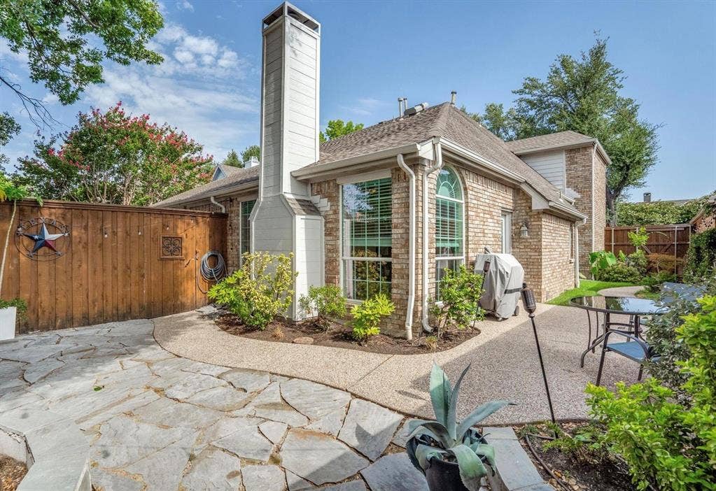 1944 Vantage Drive, Plano, TX 75075 Brick exterior with an arched window, a prominent chimney, and a gravel roof