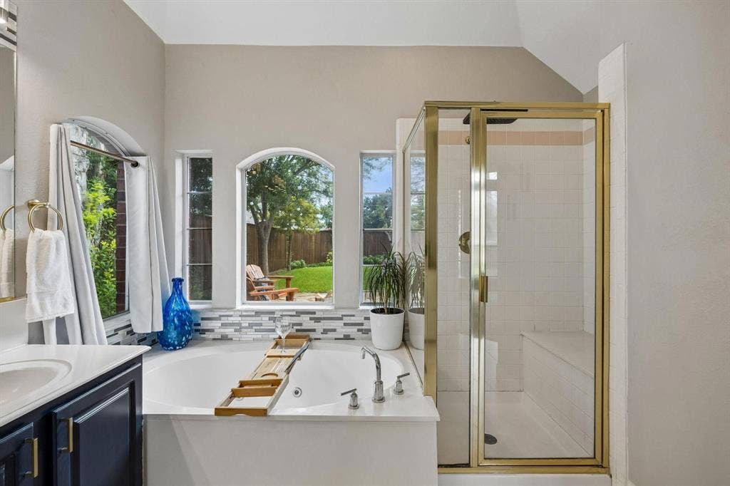 3104 Congress Avenue, Plano, TX 75025 Soaking tub with a mosaic tile surround and multiple arched windows