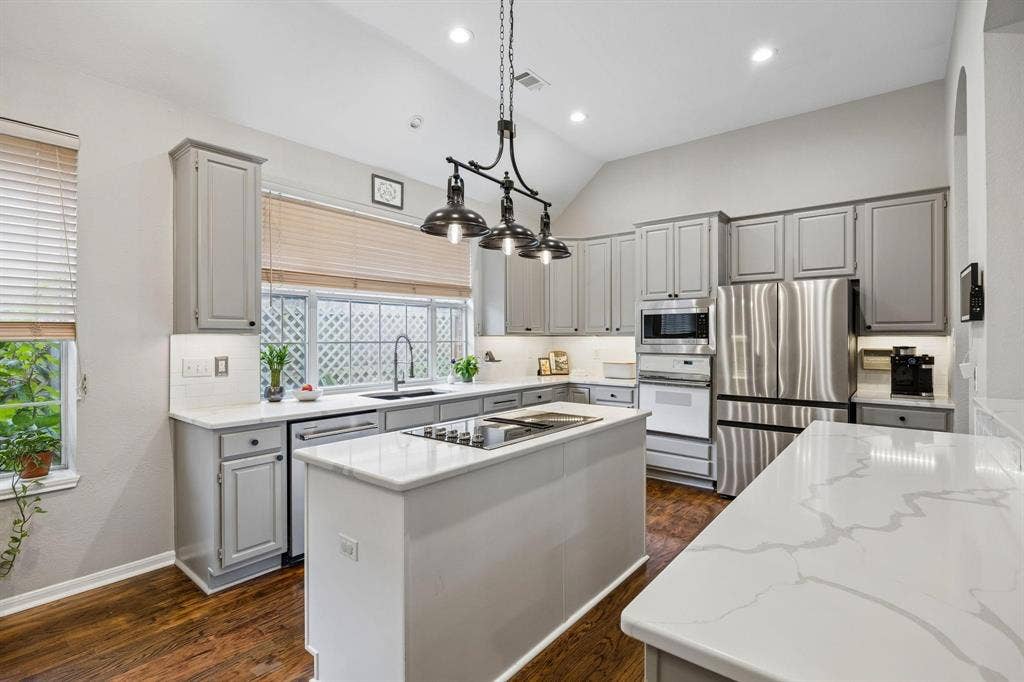 3104 Congress Avenue, Plano, TX 75025 Kitchen featuring gray cabinetry, white countertops, stainless steel appliances, a central island with cooktop, and wood-finish flooring