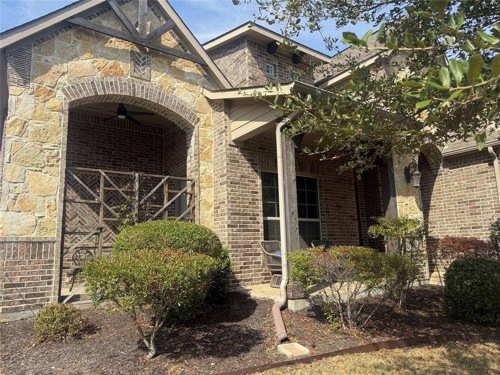 2313 Therese, Waco, TX 76712 Brick and stone exterior with arched entryway, covered porch, and exterior lighting