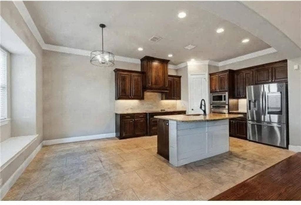 2313 Therese, Waco, TX 76712 Kitchen featuring dark wood cabinetry, a central island with a light-toned countertop, stainless steel appliances, and recessed lighting