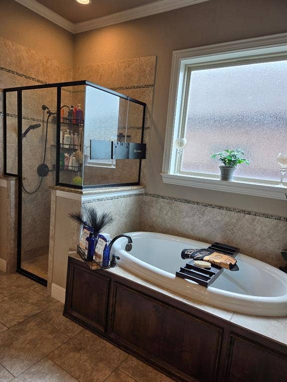 2313 Therese, Waco, TX 76712 Built-in soaking tub with dark wood paneling, a large frosted window, and an adjacent glass-enclosed shower with tile surround