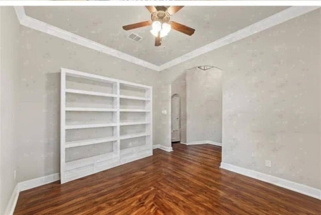 2313 Therese, Waco, TX 76712 Built-in shelving, crown molding, ceiling fan, wood-finish flooring, and arched entryway