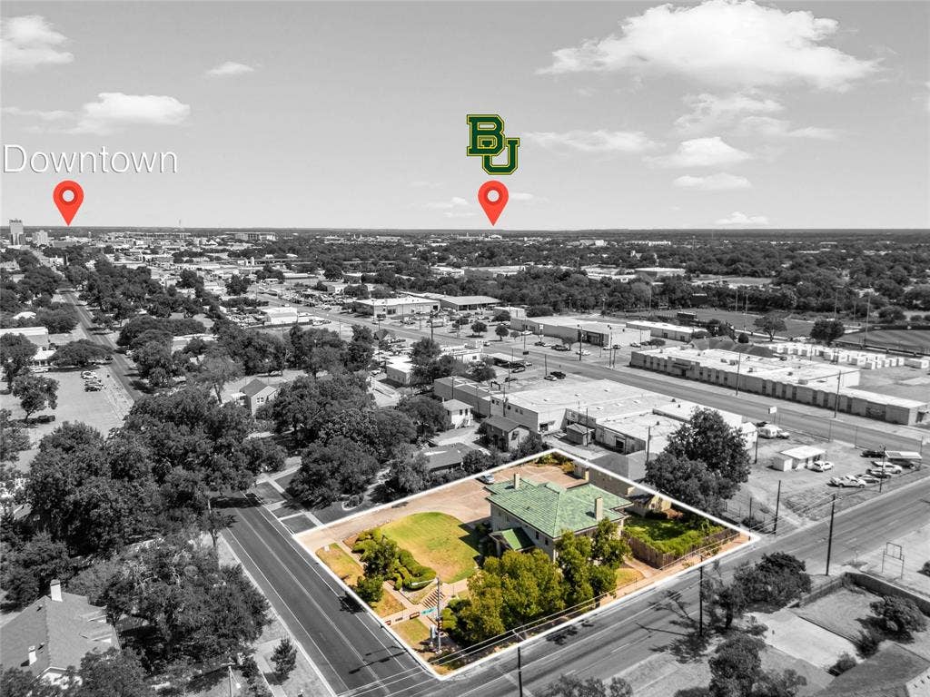 2424 Austin Avenue, Waco, TX 76701 Aerial perspective showcasing a property with a distinctive green roof, surrounded by mature trees and landscaped grounds