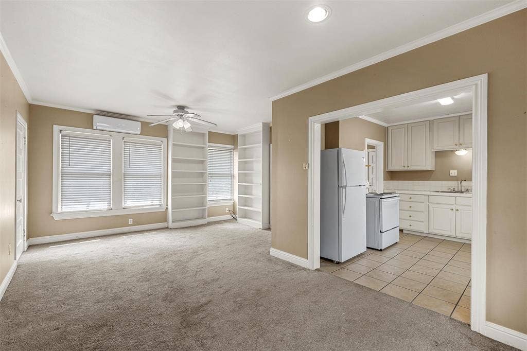 2424 Austin Avenue, Waco, TX 76701 Carpeted living area with built-in shelving, ceiling fan, and window blinds