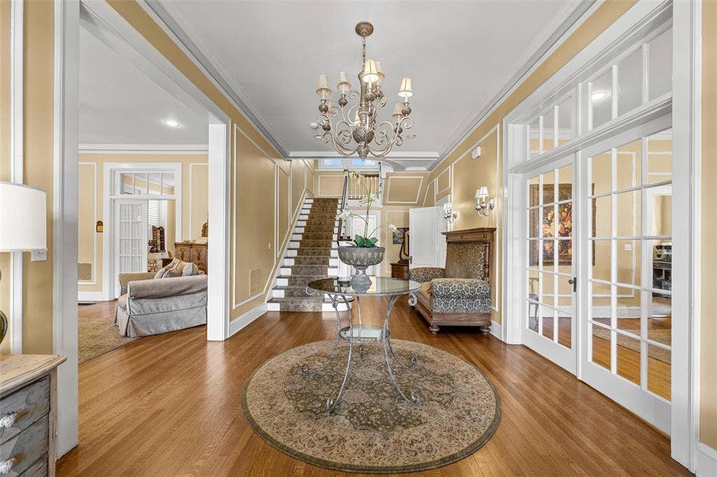 2424 Austin Avenue, Waco, TX 76701 Hardwood flooring, an ornate chandelier, a staircase with a runner, and interior French doors