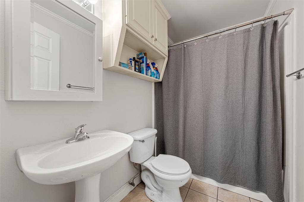 2424 Austin Avenue, Waco, TX 76701 Bathroom featuring a pedestal sink, white toilet, and tile flooring