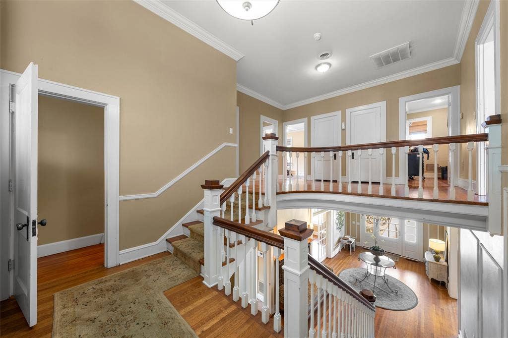 2424 Austin Avenue, Waco, TX 76701 Grand two-story foyer with hardwood flooring, a curved second-story landing, white balusters, and wood handrails