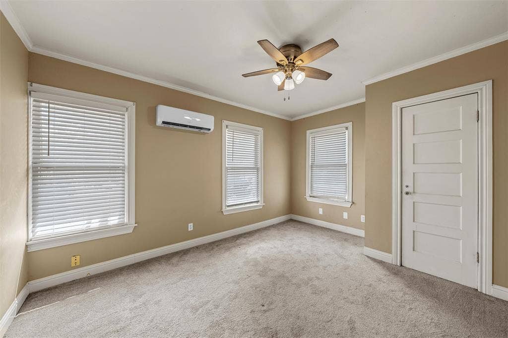 2424 Austin Avenue, Waco, TX 76701 Plush carpeting, ceiling fan, two windows with blinds, mini-split air conditioning unit, and a five-panel interior door