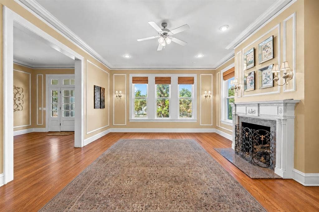 2424 Austin Avenue, Waco, TX 76701 Hardwood flooring, decorative wall molding, fireplace with an ornate mantel, multiple windows, and recessed lighting