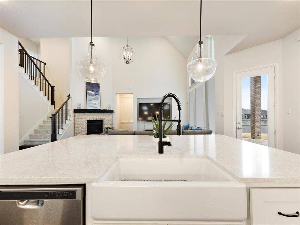 508 N Pecan Parkway, Northlake, TX 76247 Spacious kitchen island with a white farmhouse sink, matte black faucet, and stainless steel dishwasher