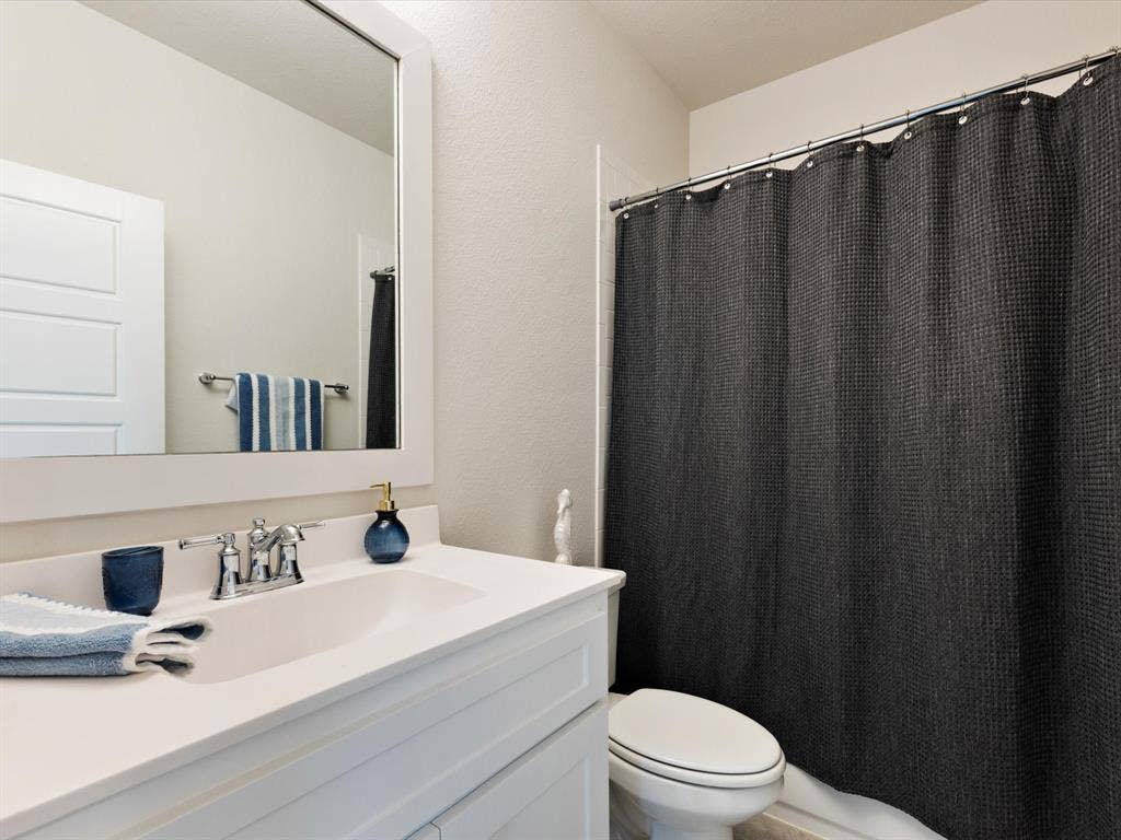 508 N Pecan Parkway, Northlake, TX 76247 White vanity with an integrated sink, polished chrome faucet, and a framed wall mirror