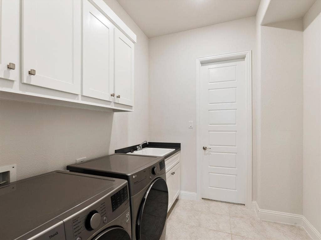 508 N Pecan Parkway, Northlake, TX 76247 White upper cabinetry, dark countertop, single basin sink, white shaker-style door, and light-toned floor tile
