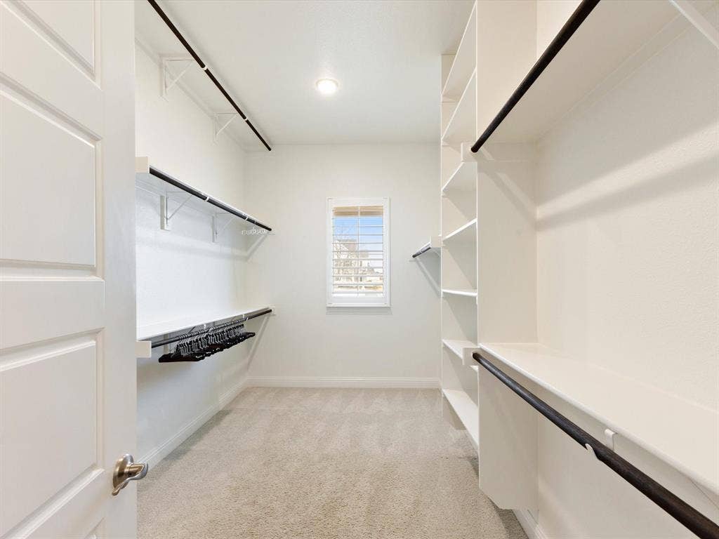 508 N Pecan Parkway, Northlake, TX 76247 Spacious closet with built-in shelving, multiple hanging rods, recessed lighting, and a window with plantation shutters