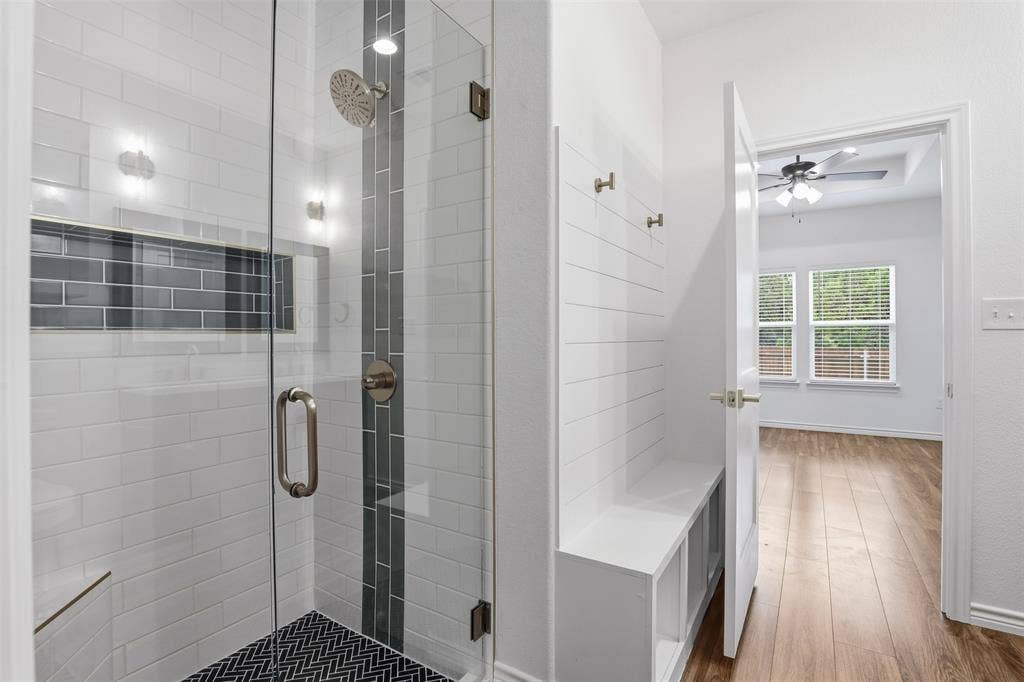 5718 Barkridge Drive, Granbury, TX 76048 Large Primary Shower with Glass door and custom tile work on floor, waterfall tile, and large niche