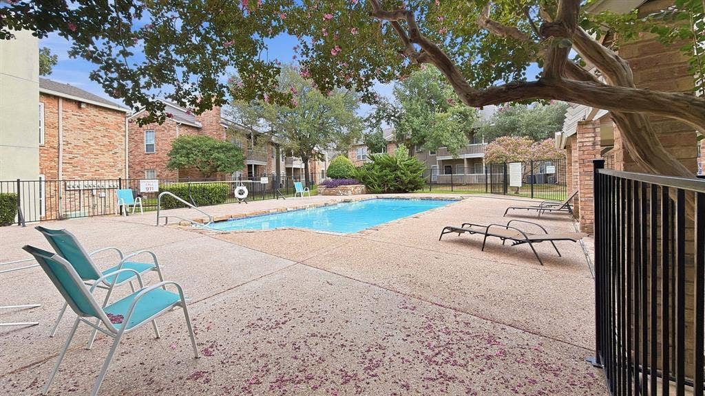 1700 Amelia Court, #126, Plano, TX 75075 Outdoor swimming pool with concrete decking, surrounding brick buildings, and mature trees
